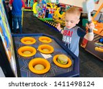 Small photo of Roseville, CA - May 25, 2019: Boy playing a whack a mole burger game inside Chuck E Cheese.