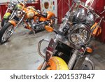 Small photo of Fairfield, CA - September 3, 2022: Motorcycles on display inside Jelly Belly museum, with focus on the headlight of this orange Victory kingpin bike.