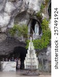 Small photo of LOURDES - JULY 23, 2014: Candles displayed at the cave at Massabielle in Lourdes, where St. Bernadette Soubirous claimed to have seen the Blessed Virgin Mary. It now is a religious grotto.
