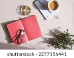 aesthetic minimalist workspace in trendy 2023 colors. Home office, blog and social media concept. Flat lay of note book, coffee and glasses in morning sun