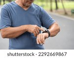 Small photo of Close up Asian senior man checking his heartbeat with smart watch at nature park. Mature Adult male checking pulse after jogging. Fitness tracker