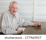 Old Man Holding Glass With...