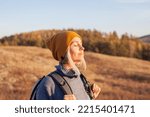 Small photo of Middle aged woman hiking and going camping in nature. Person with backpack walking in autumn forest