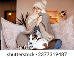 Dull middle aged woman save herself from freezing wear winter clothes muffle up in blanket think of buying radiator heater. Shivering young lady sit on sofa in plaid ponder on much too cold at home