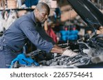 Garage Mechanic African Black male professional working car auto service checking engine oil