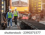 Small photo of Professional engineer mechanic team working together in locomotive train deport work checking train spare parts in the locomotive maintenance shop.