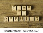 time to rebuild text on wooden cubes on a wooden background