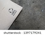 Small photo of Barcelona,Catalonia / Spain - May 10, 2019: Unused napkin, serviette lies on a stone table with a one hundred per cent recyclable logo emphasising the need for recycling. Graphic image and copy space