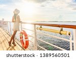 Luxury cruise ship travel elegant tourist woman watching sunset on balcony deck of Europe mediterranean cruising destination. Summer vacation cruiseship sailing away on holiday.