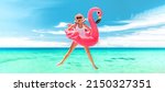 Small photo of Vacation beach woman jumping of joy with pink flamingo pool float for summer holidays on ocean banner background. Fun travel excited girl for luxury Caribbean holiday panoramic.