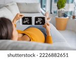 Small photo of Ultrasound showing fetus. Pregnancy concept with pregnant woman looking at first photo of her baby, happily expecting the birth of her 1st child. First trimester pregnancy