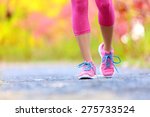 Walking and jogging woman with athletic legs and running shoes. Female walking on trail in forest in healthy lifestyle concept with close up on running shoes. Female athlete jogger training outdoors.