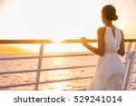Cruise ship vacation woman enjoying sunset on travel at sea. Elegant happy woman in white dress looking at ocean relaxing on luxury cruise liner boat.