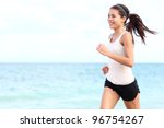 Running woman. Female runner jogging during outdoor workout on beach. Beautiful fit mixed race Fitness model outdoors.