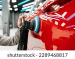 Small photo of Professional vehicle polishing and detailing service in a modern car workshop. Brightly lit workspace with large led lights. High quality car valeting concept.