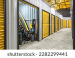 Small photo of Corridor of self storage unit with yellow doors. Rental Storage Units
