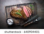 Fresh grilled meat. Grilled beef steak medium rare on wooden board. Top view.