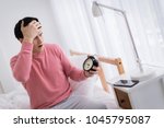 smart caucasian man iw wakeup late  on bed with black alarm clock in white room background