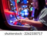 Small photo of Slot Machine Play Time. Female Gambler Hand hold money bill ready to win the game with one best shot casino close up