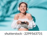 delight freshness asia woman hand using smartphone application device choosing song for headphone listen,summer vacation woman smiling enjoy day time of summer travel studio shot on colour background