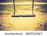 Vintage photo of empty swing on children playground in city. Old fashioned colors photography.