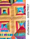 Small photo of Part of symmetric geometry pattern color patchwork quilt as background. Colorful Scrappy blanket. Handmade.